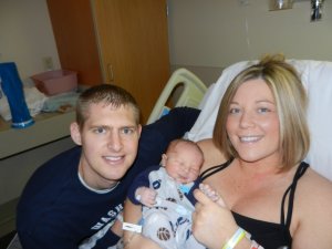 Parents in a hospital bed with newborn baby