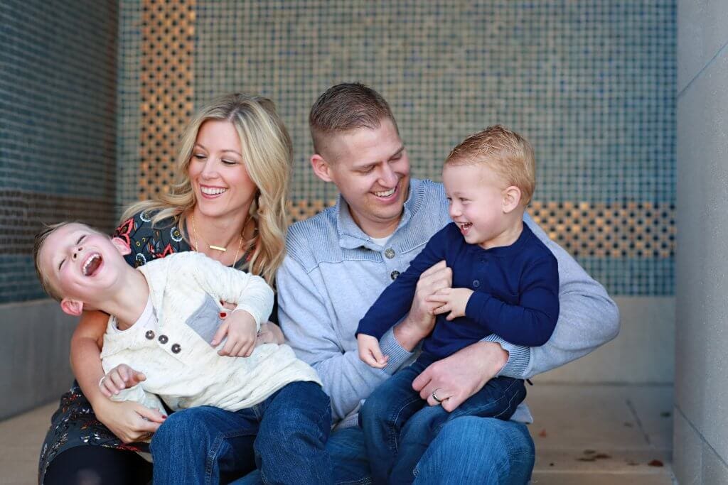 Husband and wife laughing with their two boys