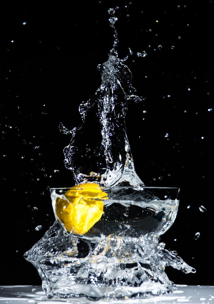 Water splashing in bowl with lemon