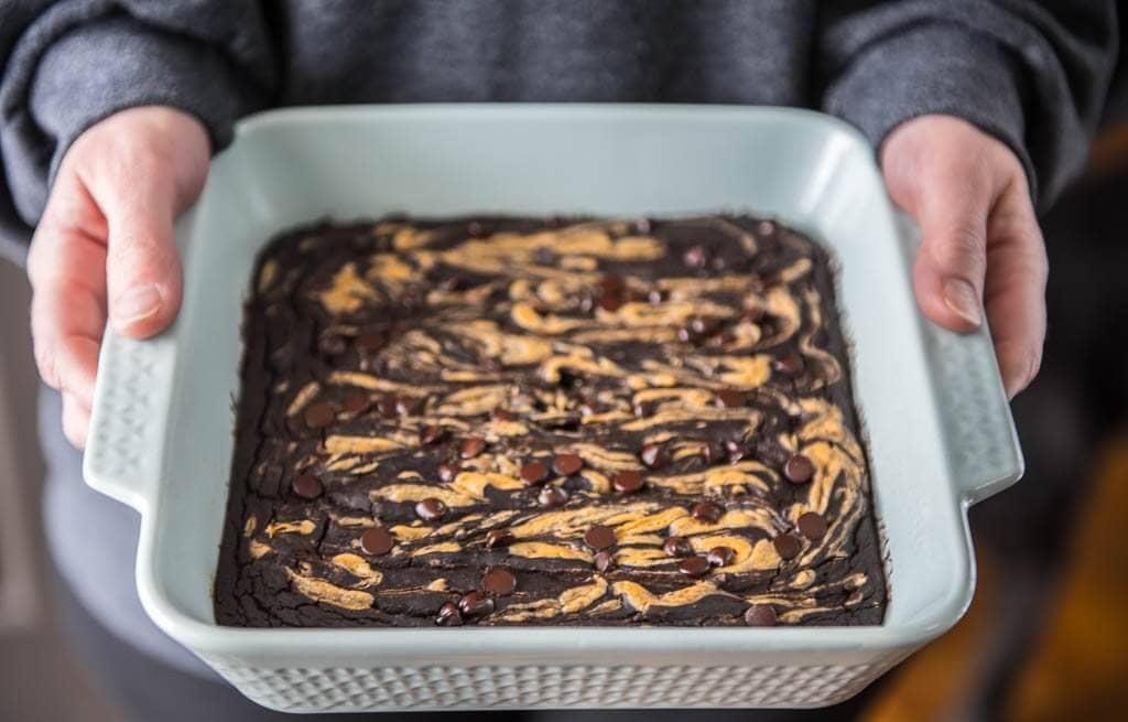 Holding a pan of fresh black bean brownies fresh out of the oven.