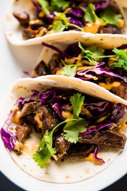 Close up picture of korean beef tacos with cabbage and cilantro
