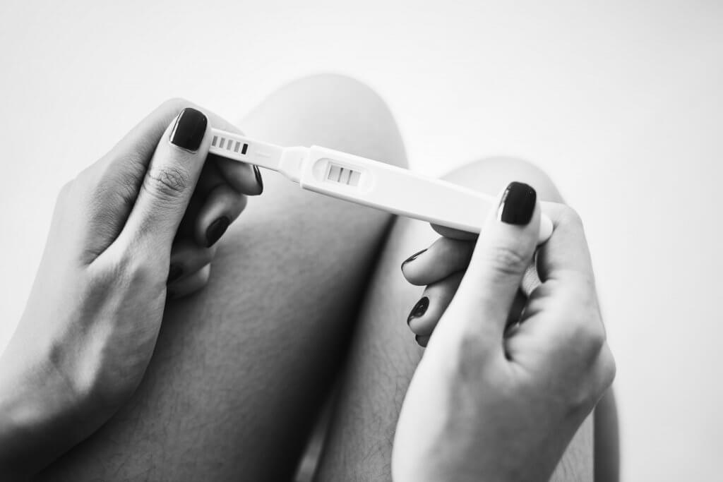 black and white photo of a positive pregnancy test