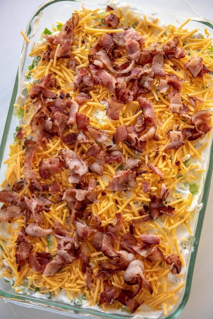 Overhead view of 7 layer salad with cheese and bacon on top