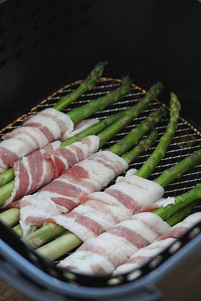 Asparagus wrapped in raw bacon in an air fryer