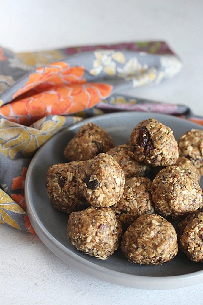 Picture of oatmeal raisin protein balls on a grey plate with a floral napkin