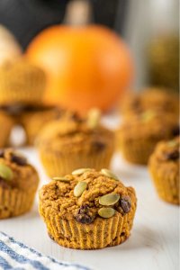 Healthy Pumpkin Muffins on a table with a pumpkin in the foreground