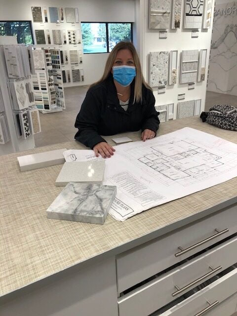 A woman with a set of house plans at a design studio