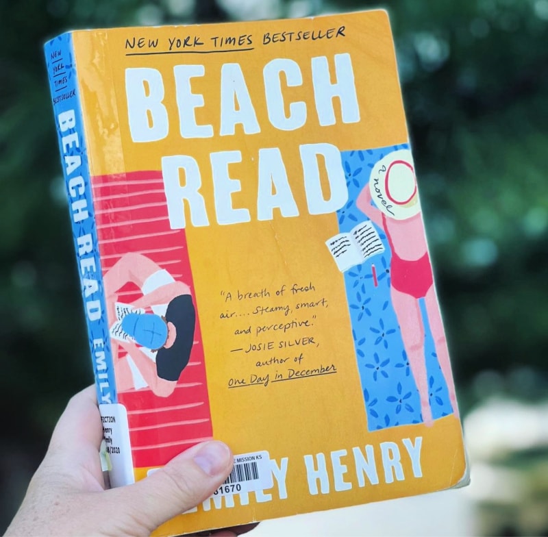 the book beach read being held up in front of a green background