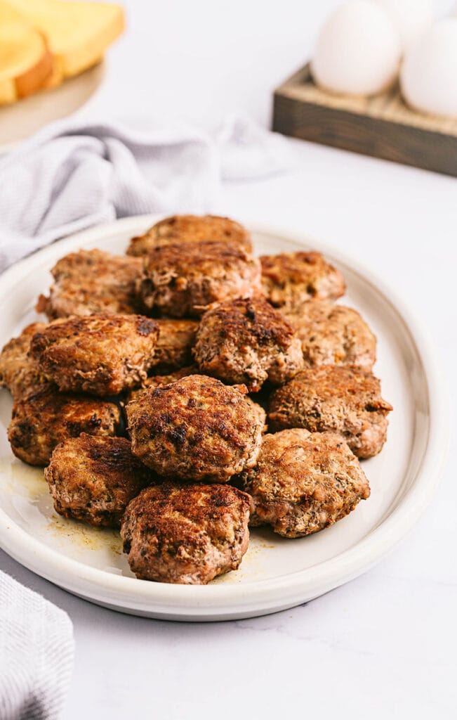 a pile of homemade sausage breakfast patties on a white plate
