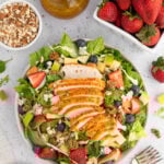 overhead picture of market salad with the dressing, strawberries and nuts