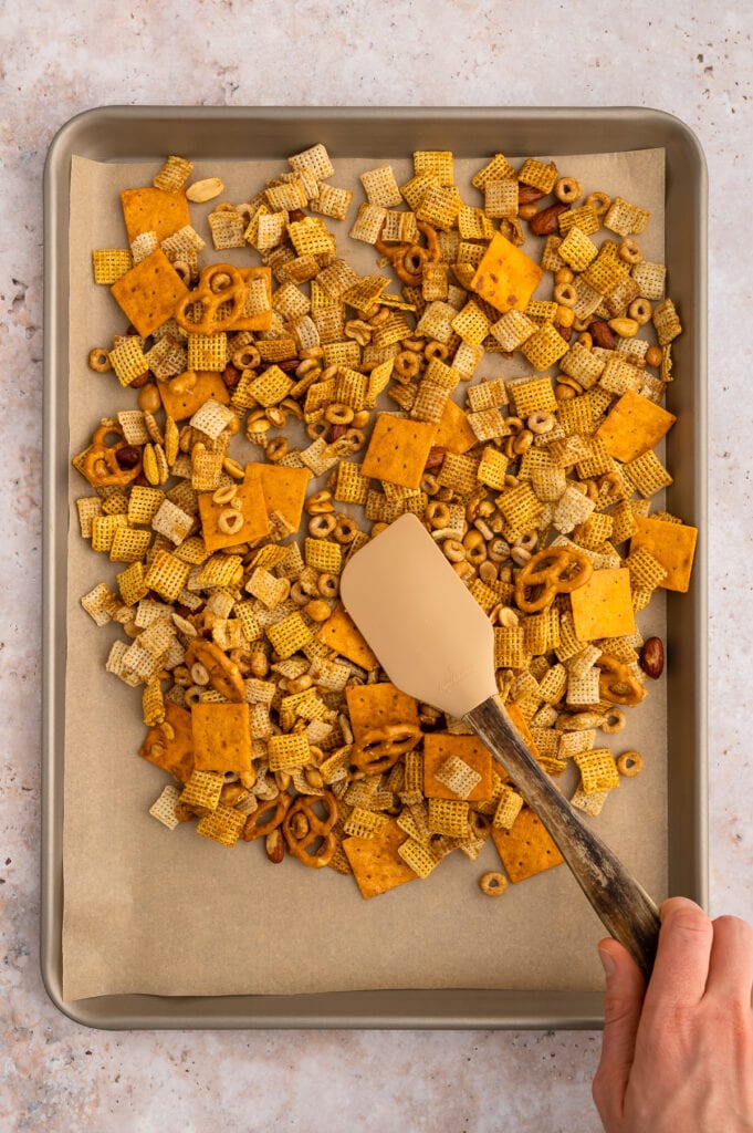 spreading out the gluten free chex mix onto a pan